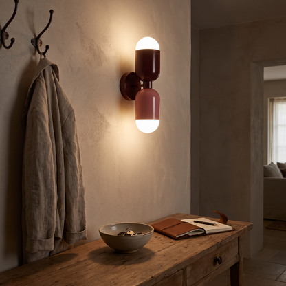 Dual bulb wall lamp lit above a console at night