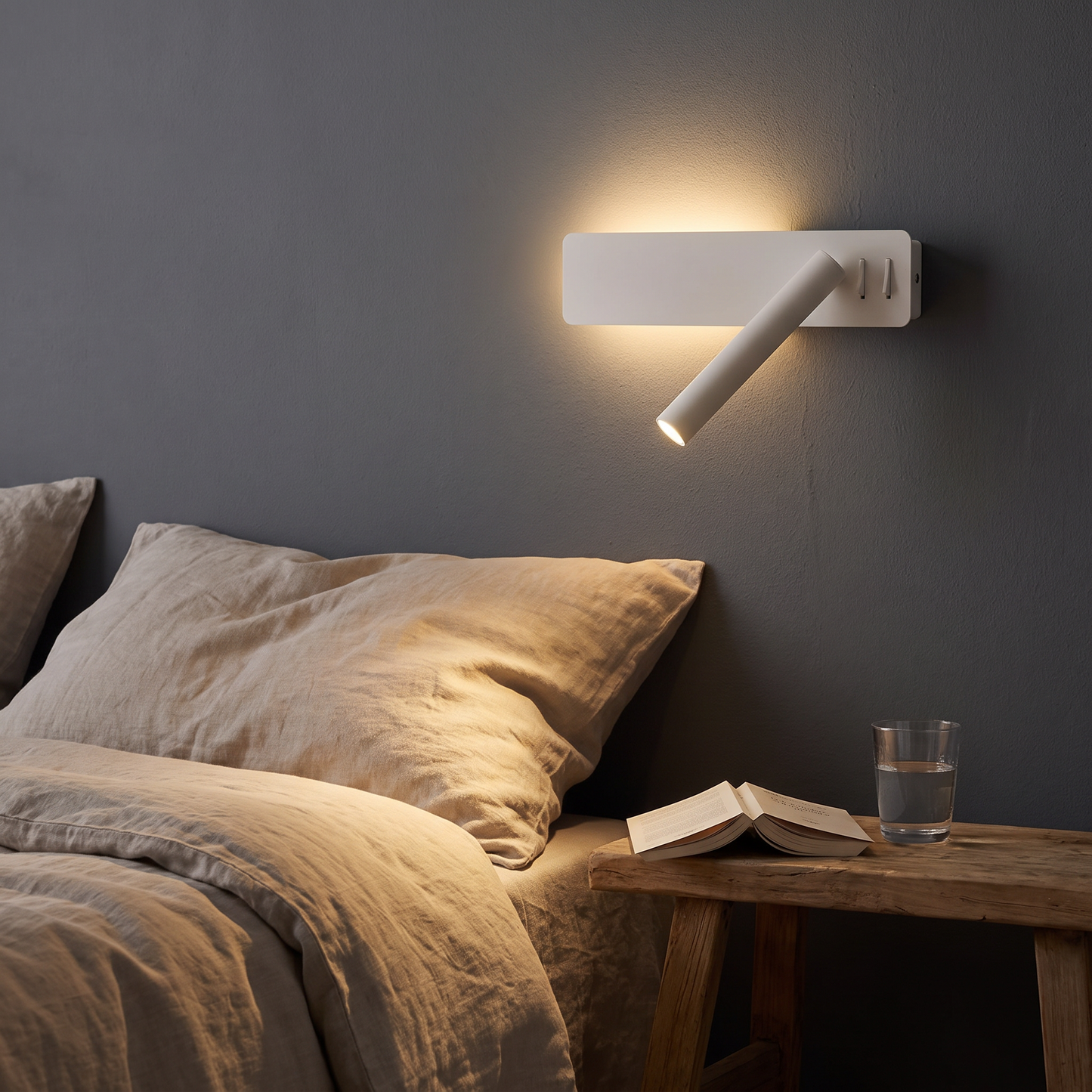 Reading arm wall light lit over a bed at night